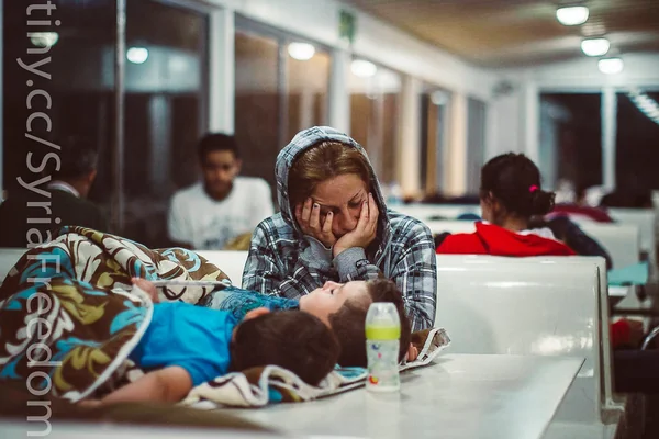 A refugee sleeps with her children on a ferry traveling from the northeastern Greek island of Lesbos to the Athens port of Piraeus, Sept. 9, 2015.