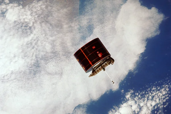 View of the Syncom IV satellite in orbit over the earth