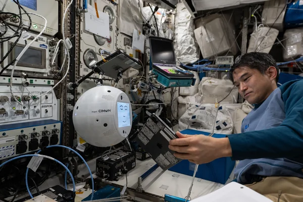 JAXA astronaut Takuya Onishi sets up the CIMON AI-powered robotic assistant