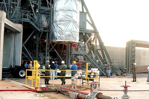 KENNEDY SPACE CENTER, FLA.  -  After dawn,  the Space Infrared Telescope Facility (SIRTF) is lifted up the mobile service tower on Launch Pad 17-B, Cape Canaveral Air Force Station.  SIRTF will be attached to the Delta II rocket and encapsulated in its fairing before launch.   Consisting of three cryogenically cooled science instruments and an 0.85-meter telescope, SIRTF is one of NASA’s largest infrared telescopes to be launched.  It is the fourth and final element in NASA’s family of orbiting “Great Observatories.”  SIRTF will obtain images and spectra by detecting the infrared energy, or heat, radiated by objects in space. Most of this infrared radiation is blocked by the Earth's atmosphere and cannot be observed from the ground.