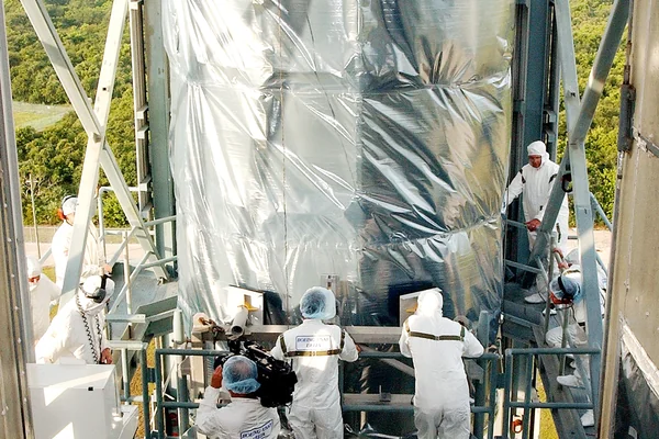 KENNEDY SPACE CENTER, FLA.  -  Workers on the mobile service tower on Launch Pad 17-B, Cape Canaveral Air Force Station, wait for the Space Infrared Telescope Facility (SIRTF) to reach their level.  SIRTF will be attached to the Delta II rocket and encapsulated in its fairing before launch.   Consisting of three cryogenically cooled science instruments and an 0.85-meter telescope, SIRTF is one of NASA’s largest infrared telescopes to be launched.  It is the fourth and final element in NASA’s family of orbiting “Great Observatories.”  SIRTF will obtain images and spectra by detecting the infrared energy, or heat, radiated by objects in space. Most of this infrared radiation is blocked by the Earth's atmosphere and cannot be observed from the ground.