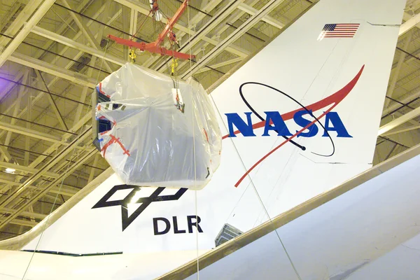 SOFIA's primary mirror assembly is lifted above wing level prior to its reinstallation in the telescope cavity of NASA's 747 airborne observatory Oct. 8, 2008