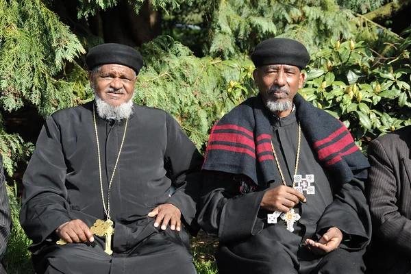 Holding blessed Christian crosses, senior religious leaders in black and red garments, from north African country Eritrea (Punt, 'Ta Netjeru,' meaning god's land), at the 20th year anniversary of Eritrea's independence, Volunteer Park, Seattle, Washington