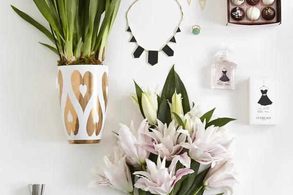 purple phalaenopsis orchid in vase white and pink lilies chocolate and assorted truffles stainless steel cocktail drink mixer bar tools lime bitters necklace earrings ring jewelry perfume
