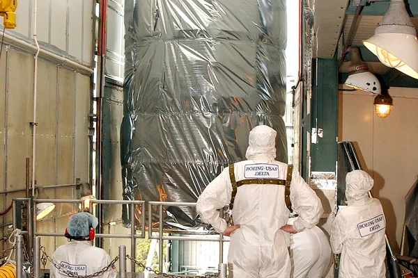 KENNEDY SPACE CENTER, FLA.  -  Workers on the mobile service tower on Launch Pad 17-B, Cape Canaveral Air Force Station, watch as the Space Infrared Telescope Facility (SIRTF) clears the platform.   SIRTF will be attached to the Delta II rocket and encapsulated in its fairing before launch.   Consisting of three cryogenically cooled science instruments and an 0.85-meter telescope, SIRTF is one of NASA’s largest infrared telescopes to be launched.  It is the fourth and final element in NASA’s family of orbiting “Great Observatories.”  SIRTF will obtain images and spectra by detecting the infrared energy, or heat, radiated by objects in space. Most of this infrared radiation is blocked by the Earth's atmosphere and cannot be observed from the ground.