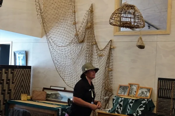 Rotorua. At Whakarewarewa Living Maori Village in the womans weaving school a Maori woman explains the use of flax leaves in traditional weaving.