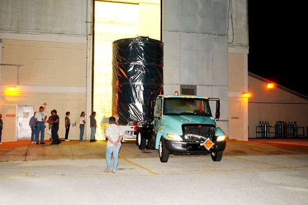 KENNEDY SPACE CENTER, FLA.  -  The Space Infrared Telescope Facility (SIRTF) is rolled out of the hangar at Cape Canaveral Air Force Station during pre-dawn hours.  It is being transported to Launch Pad 17-B where it will be lifted into the mobile service tower and prepared for launch.  SIRTF consists of three cryogenically cooled science instruments and an 0.85-meter telescope, and is one of NASA’s largest infrared telescopes to be launched.  It is the fourth and final element in NASA’s family of orbiting “Great Observatories.”  SIRTF will obtain images and spectra by detecting the infrared energy, or heat, radiated by objects in space. Most of this infrared radiation is blocked by the Earth's atmosphere and cannot be observed from the ground.