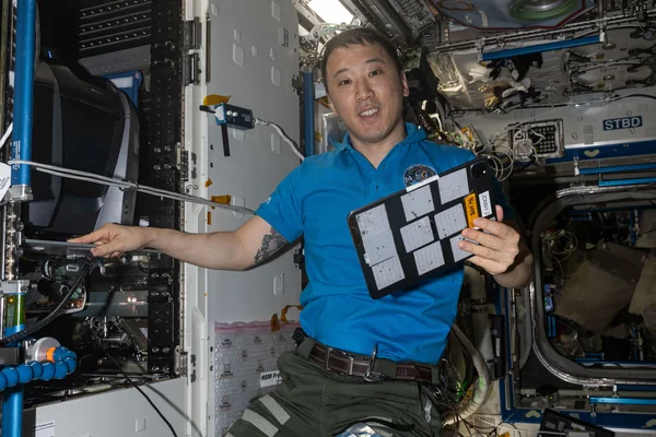 NASA astronaut Jonny Kim poses for a portrait while servicing a fluorescence microscope