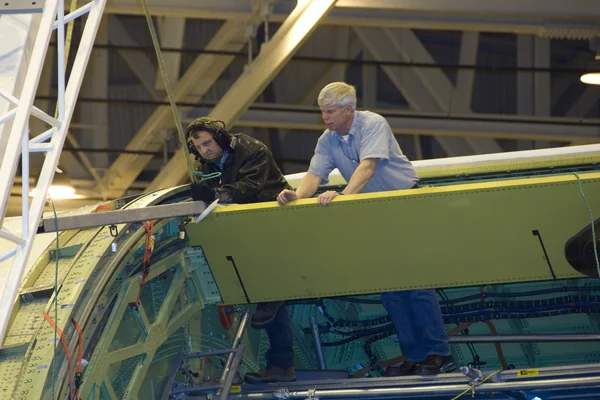 Technicians carefully maneuver a spreader bar into place before removing the telescope aperture assembly from NASA's SOFIA infrared observatory Boeing 747SP