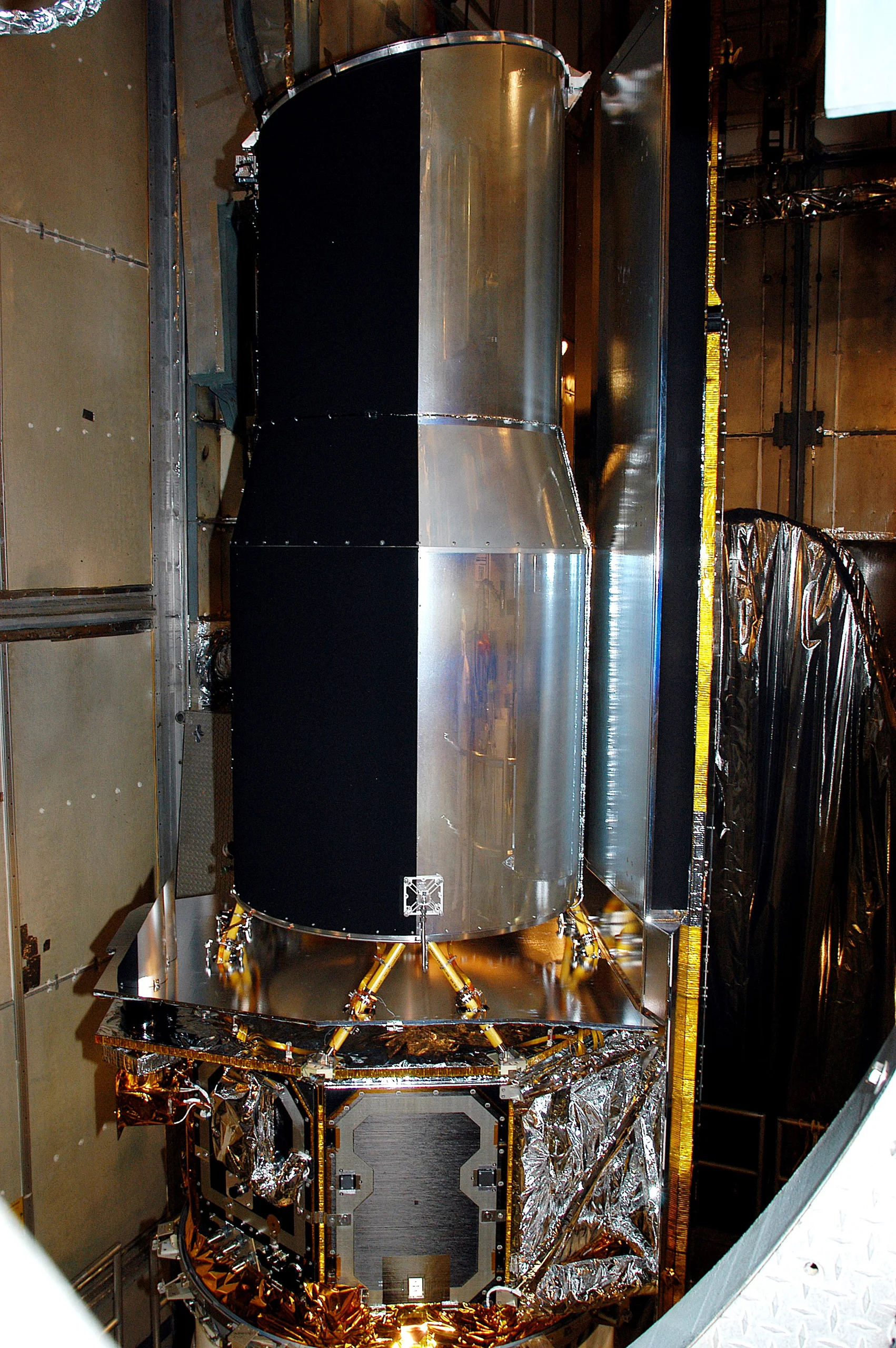 KENNEDY SPACE CENTER, FLA.  - In the mobile service tower on Launch Pad 17-B, Cape Canaveral Air Force Station, the Space Infrared Telescope Facility (SIRTF) waits for encapsulation. SIRTF will obtain images and spectra by detecting the infrared energy, or heat, radiated by objects in space. Consisting of a 0.85-meter telescope and three cryogenically cooled science instruments, SIRTF will be the largest infrared telescope ever launched into space. It is the fourth and final element in NASA’s family of orbiting “Great Observatories.” Its highly sensitive instruments will give a unique view of the Universe and peer into regions of space that are hidden from optical telescopes.