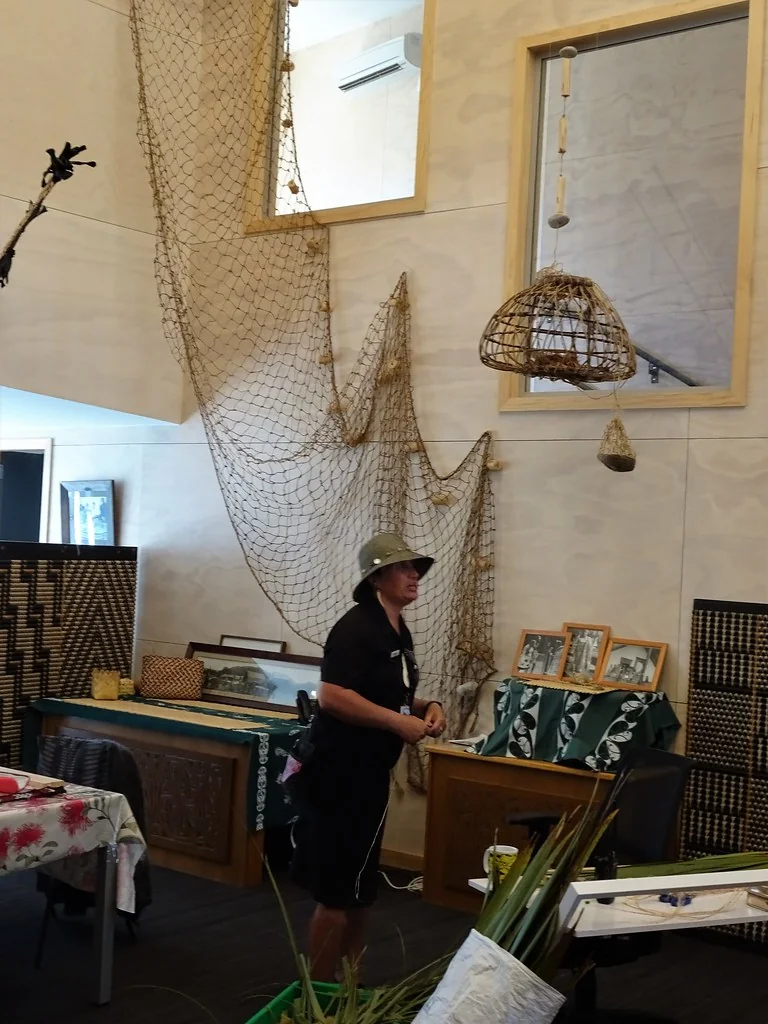 Rotorua. At Whakarewarewa Living Maori Village in the womans weaving school a Maori woman explains the use of flax leaves in traditional weaving.