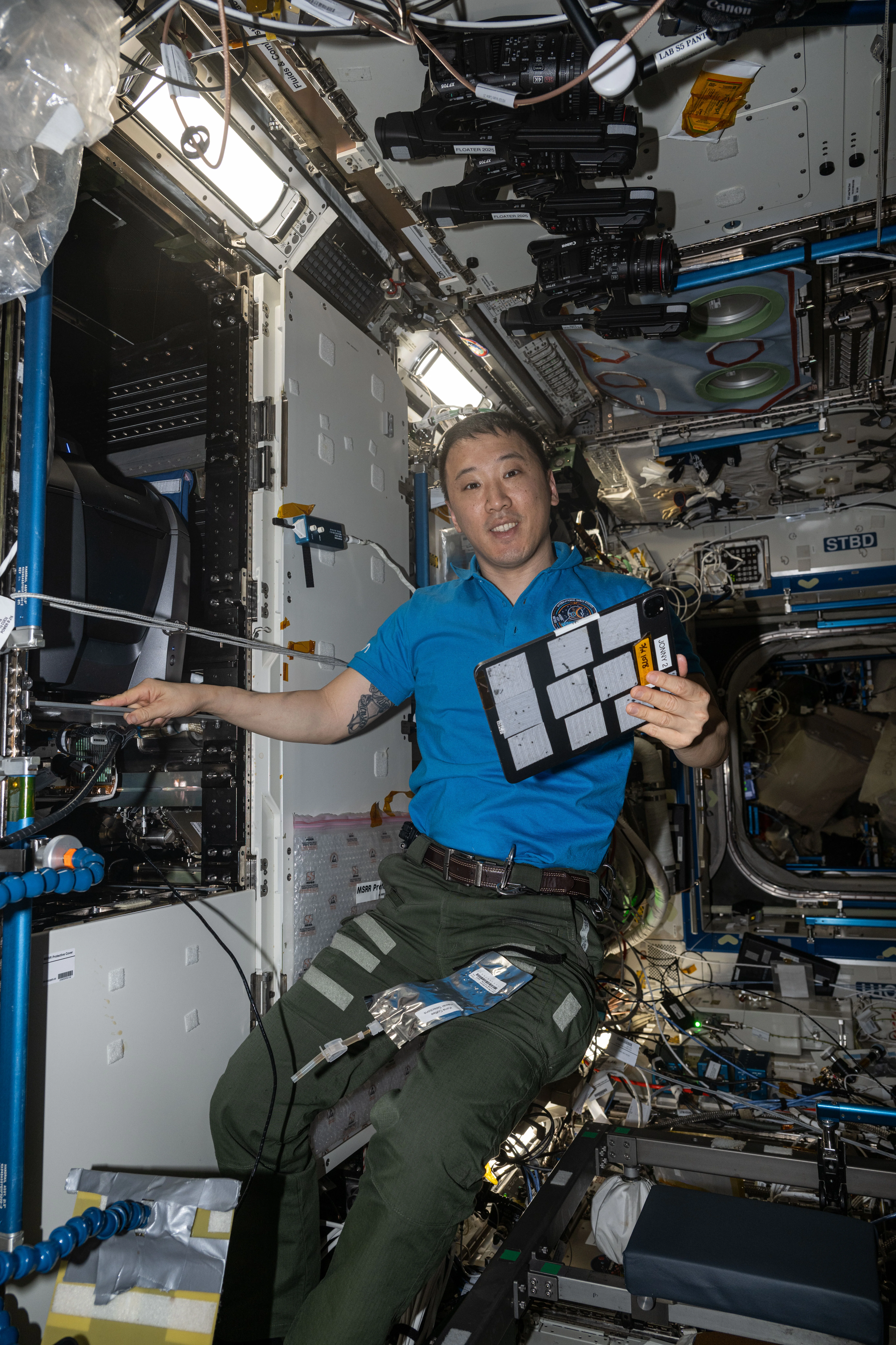 NASA astronaut Jonny Kim poses for a portrait while servicing a fluorescence microscope